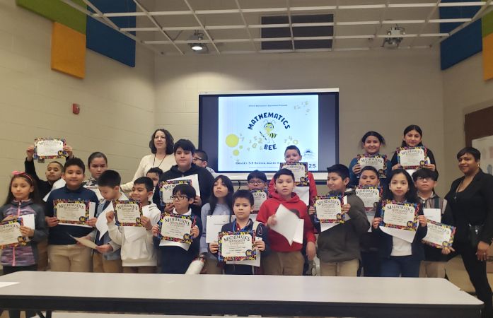  Students holding math bee certificates and smiling